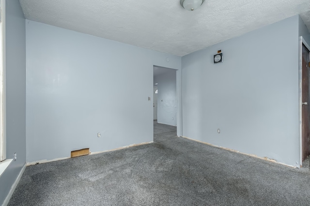 carpeted spare room featuring a textured ceiling