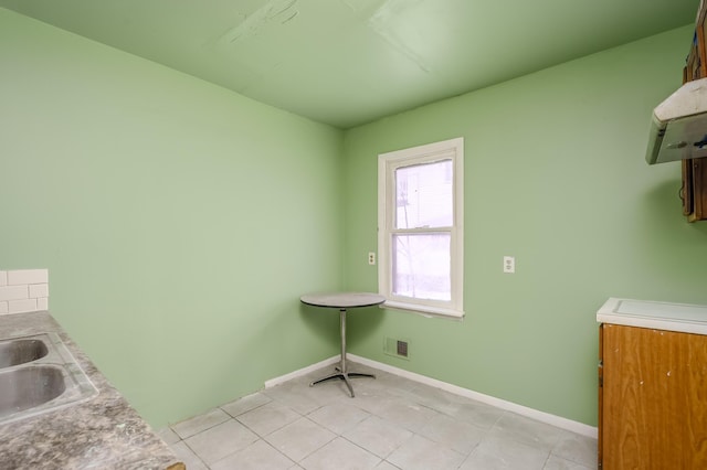 laundry area featuring sink and light tile patterned floors