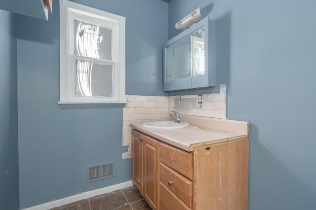 bathroom featuring tasteful backsplash, tile patterned flooring, and vanity