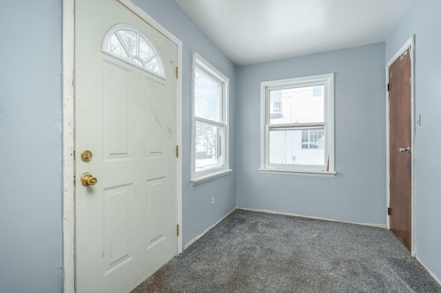 entrance foyer with dark colored carpet