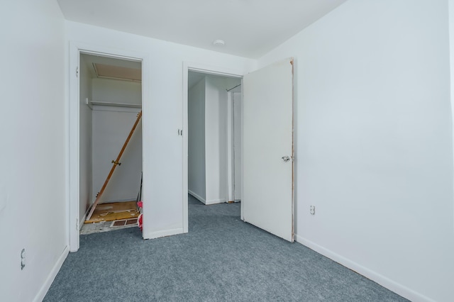 unfurnished bedroom with dark carpet and a closet