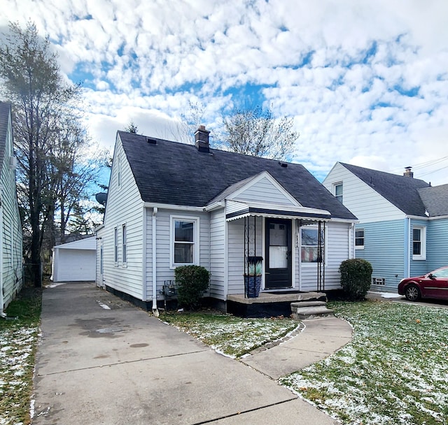 view of front of home featuring a garage, a front lawn, and an outdoor structure