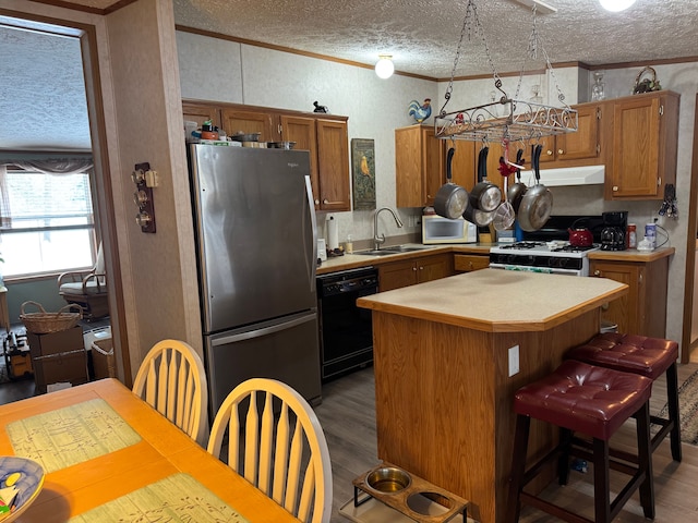 kitchen featuring dark hardwood / wood-style flooring, white appliances, a textured ceiling, sink, and a kitchen island