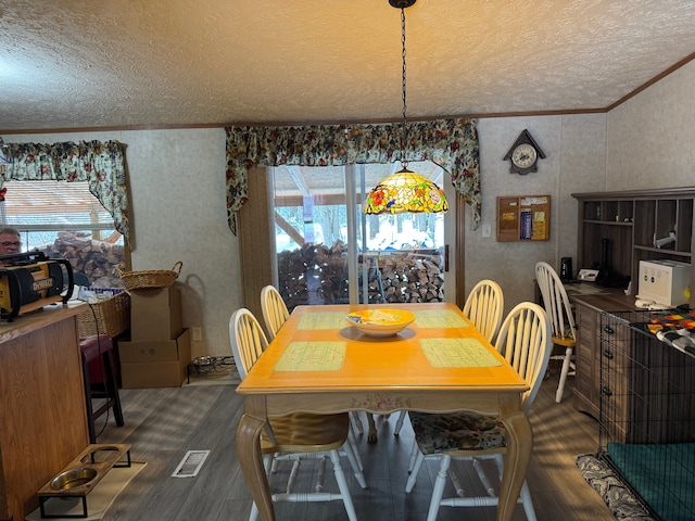 dining space with dark hardwood / wood-style flooring, ornamental molding, and a textured ceiling