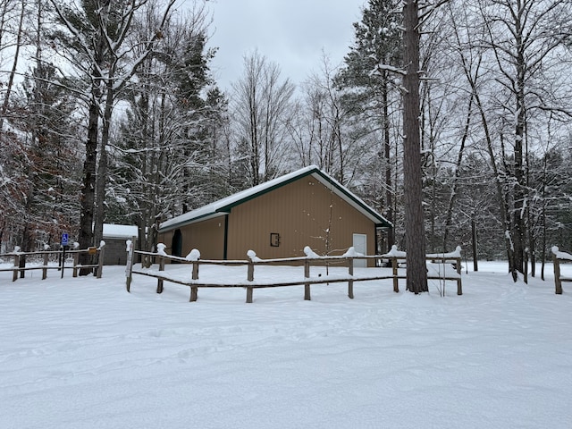 snow covered property featuring an outdoor structure