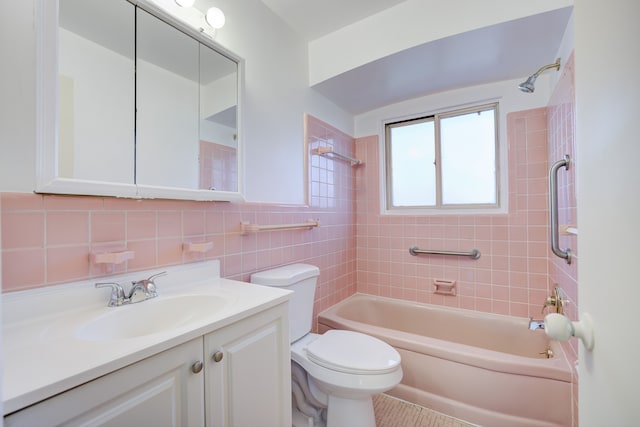 full bathroom featuring vanity, toilet, tile walls, and tiled shower / bath combo