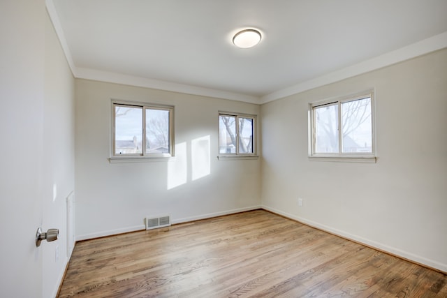 unfurnished room with light wood-type flooring and crown molding