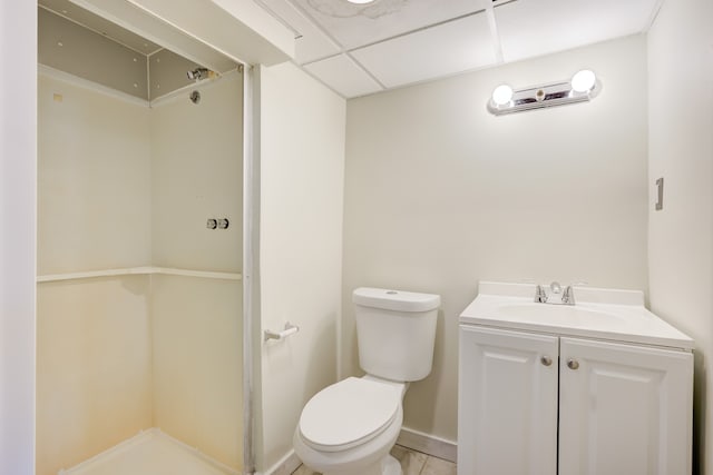 bathroom featuring tile patterned floors, a drop ceiling, vanity, and toilet