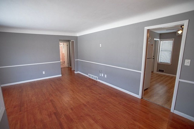 spare room with hardwood / wood-style floors and ceiling fan