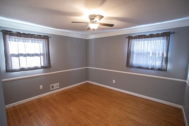 spare room with wood-type flooring, ornamental molding, and ceiling fan