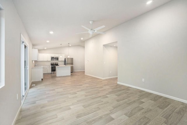 unfurnished living room with ceiling fan, lofted ceiling, and light wood-type flooring