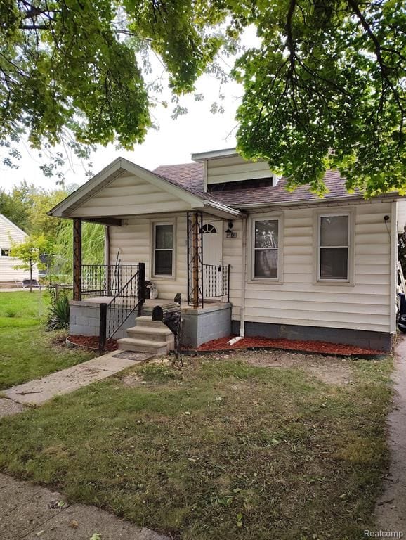 bungalow with a porch and a front lawn