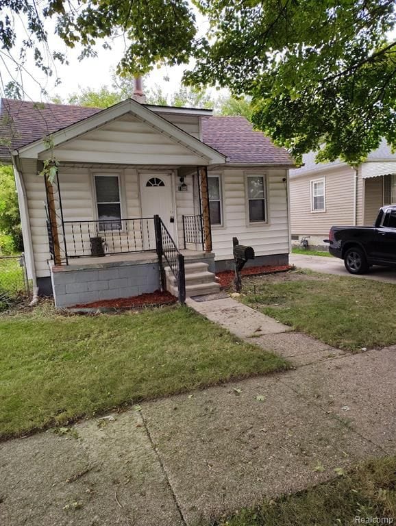 bungalow-style house with covered porch and a front lawn