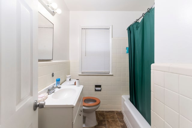 full bathroom featuring shower / bath combo, tile patterned floors, vanity, tile walls, and toilet