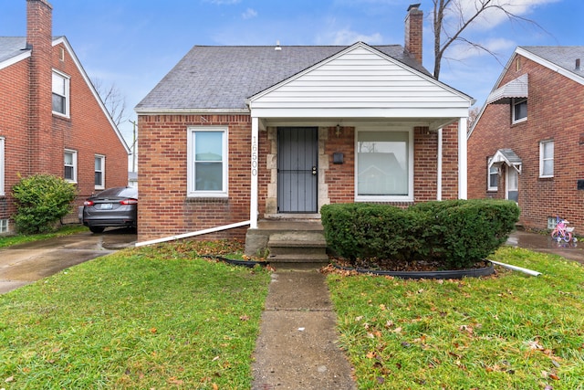 bungalow-style home featuring a front lawn