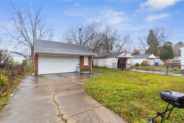 view of front of house with an outbuilding, a front lawn, and a garage