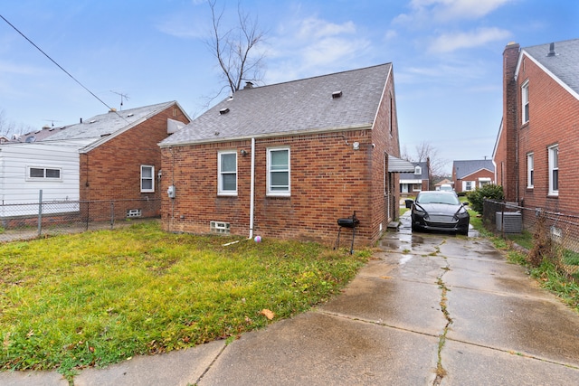 view of side of home featuring a yard and cooling unit