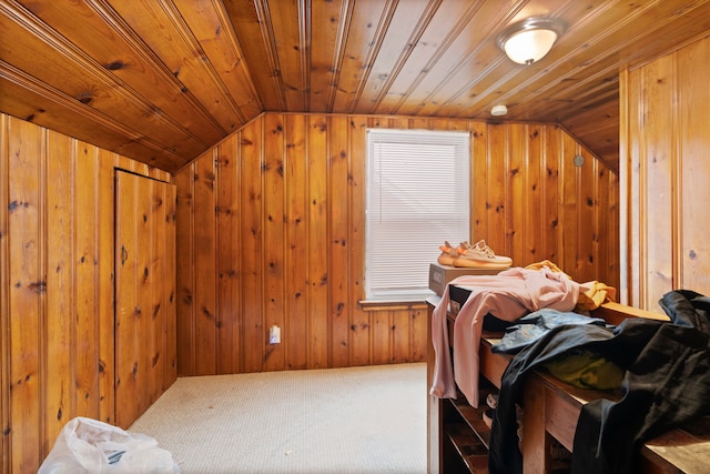 interior space featuring carpet, wood walls, wood ceiling, and vaulted ceiling