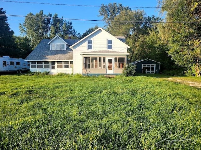 back of property with a lawn and a sunroom