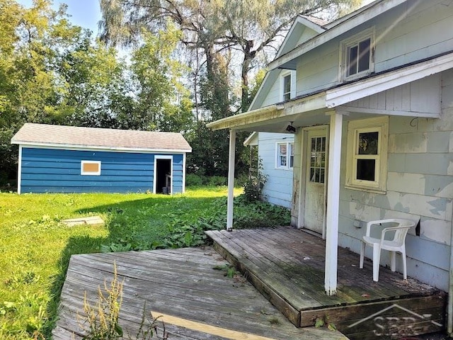 wooden deck with an outbuilding and a yard