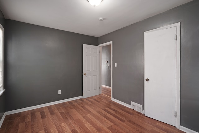 unfurnished bedroom with dark hardwood / wood-style floors