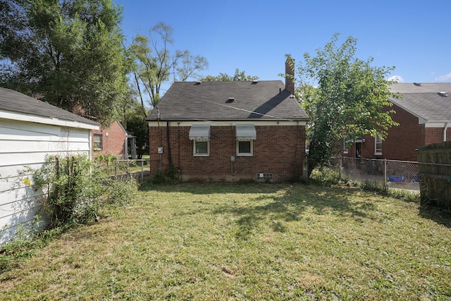 rear view of house featuring a lawn