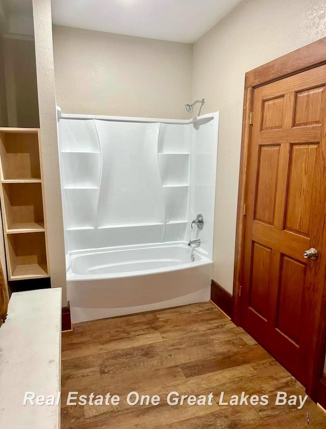 bathroom with wood-type flooring and tub / shower combination