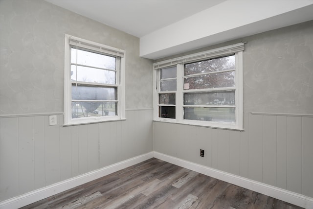 empty room with wood-type flooring and wooden walls