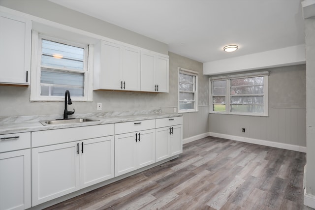 kitchen featuring light hardwood / wood-style floors, white cabinetry, and sink