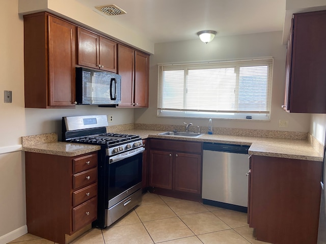 kitchen with sink, light tile patterned floors, and stainless steel appliances