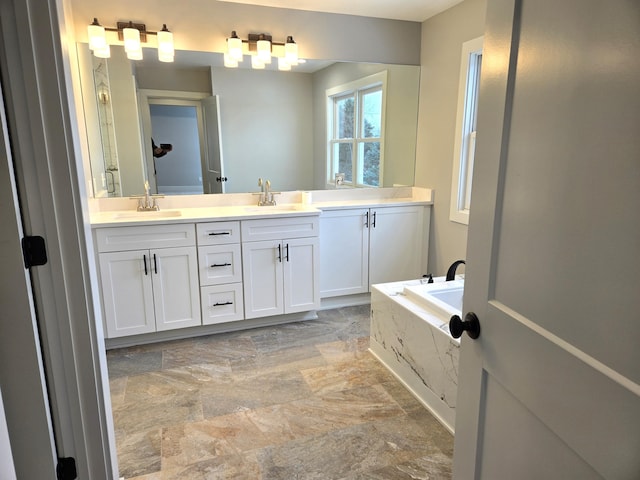 bathroom with vanity and tiled tub