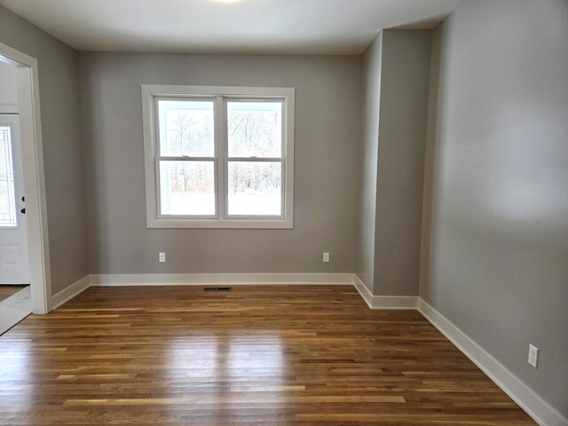 empty room with dark hardwood / wood-style flooring