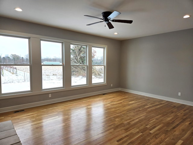 empty room with ceiling fan and light hardwood / wood-style flooring