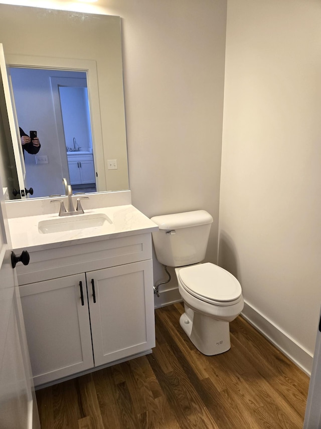 bathroom featuring vanity, wood-type flooring, and toilet