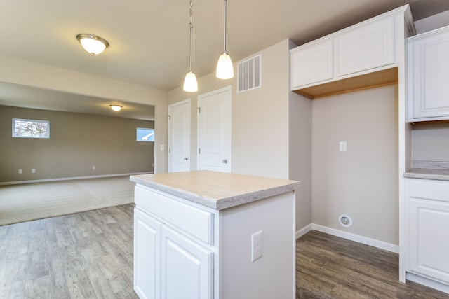 kitchen featuring light hardwood / wood-style floors, a kitchen island, white cabinetry, and hanging light fixtures