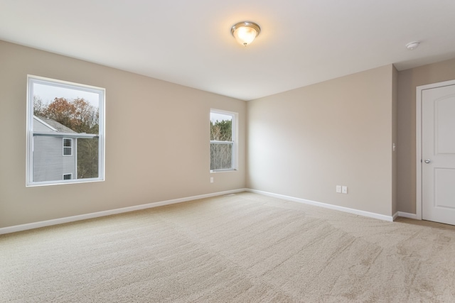 spare room featuring light colored carpet