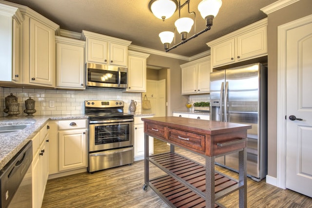 kitchen with stainless steel appliances, dark hardwood / wood-style flooring, crown molding, a textured ceiling, and decorative light fixtures