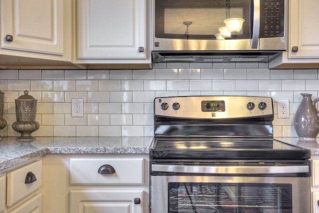 kitchen featuring decorative backsplash, appliances with stainless steel finishes, and light stone countertops