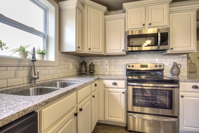 kitchen with tasteful backsplash, dark wood-type flooring, sink, and stainless steel appliances