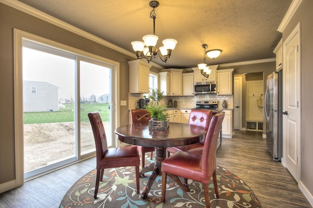 dining space featuring dark hardwood / wood-style flooring, crown molding, plenty of natural light, and a chandelier