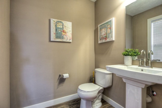 bathroom with hardwood / wood-style flooring and toilet