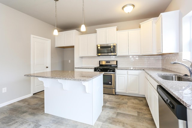 kitchen with white cabinets, a center island, sink, and appliances with stainless steel finishes