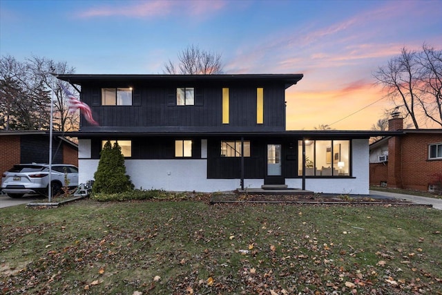 view of front of house with brick siding and a yard