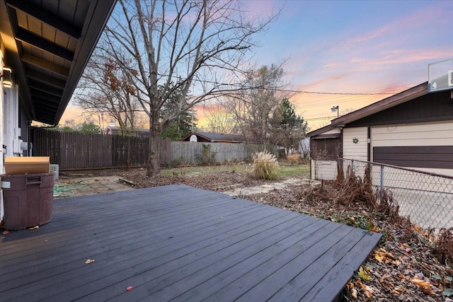 deck at dusk with a fenced backyard