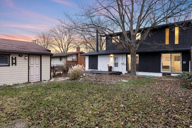 rear view of house with a yard, a chimney, and fence