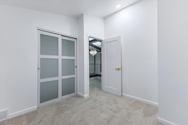 spare room with visible vents, baseboards, carpet floors, recessed lighting, and a chandelier