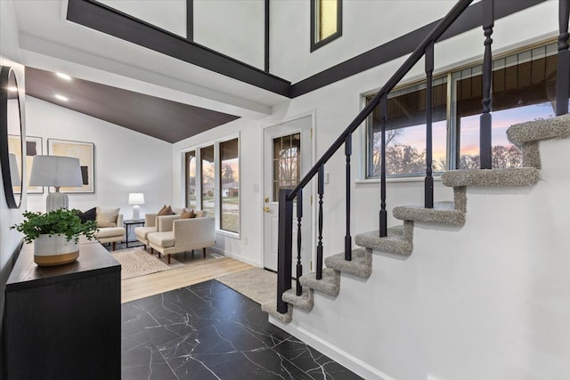 entrance foyer with stairs, vaulted ceiling, baseboards, and marble finish floor