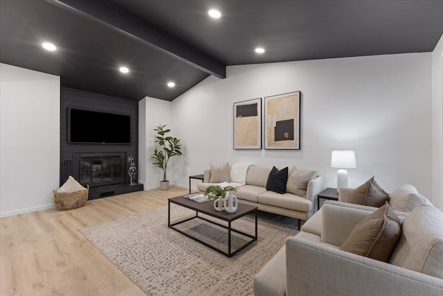 living room with wood finished floors, baseboards, lofted ceiling with beams, a fireplace, and recessed lighting