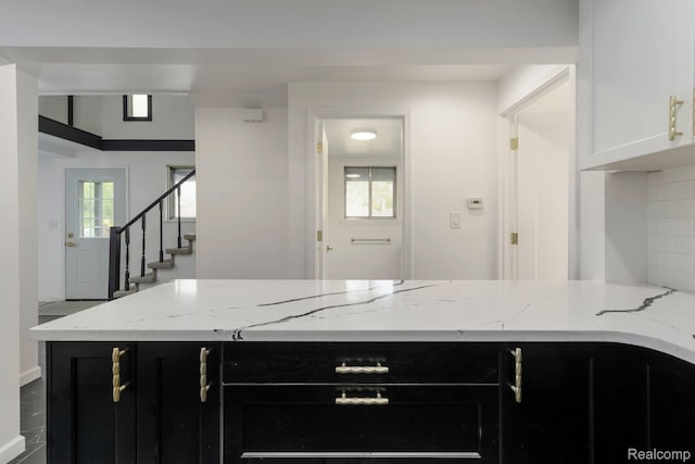 11357 Erdmann Rd, Sterling Heights, MI 48314 - kitchen featuring dark cabinetry, light stone countertops, white cabinets, and a peninsula