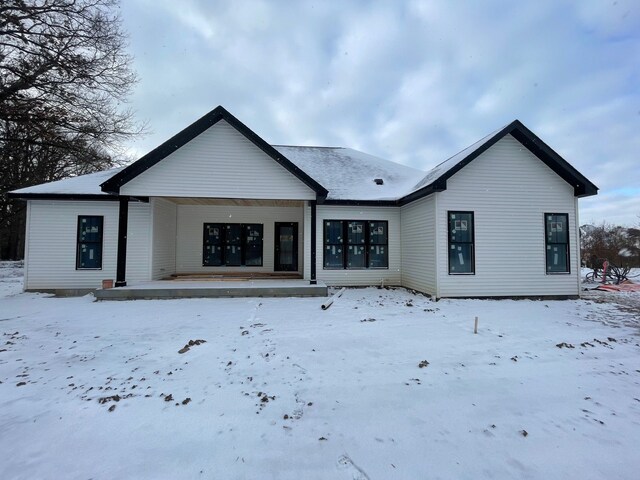 view of snow covered rear of property